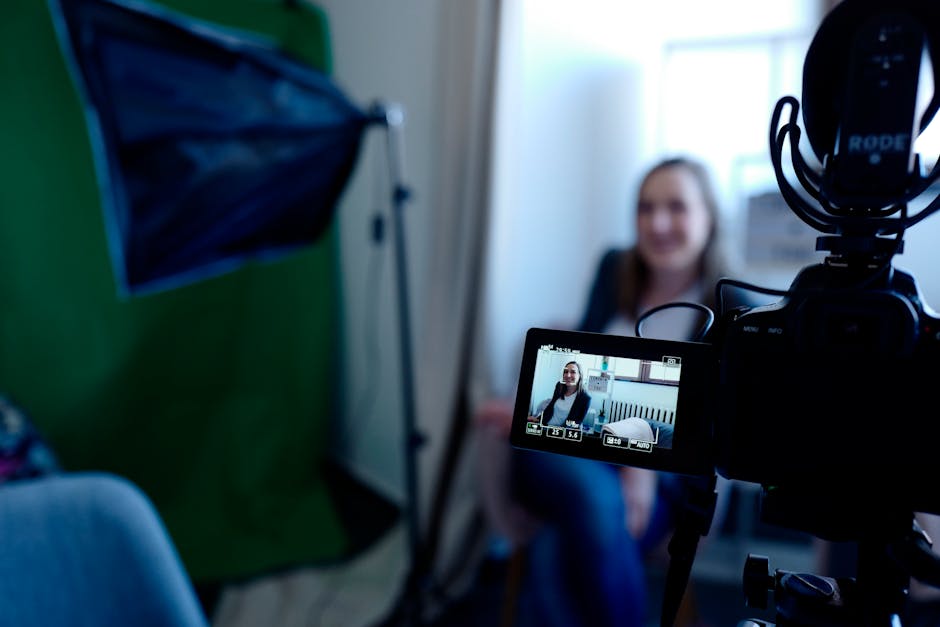 Woman being recorded in a professional studio setup, using video camera and lighting equipment